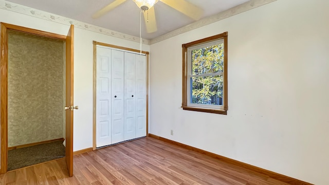 unfurnished bedroom with hardwood / wood-style floors, a closet, and ceiling fan