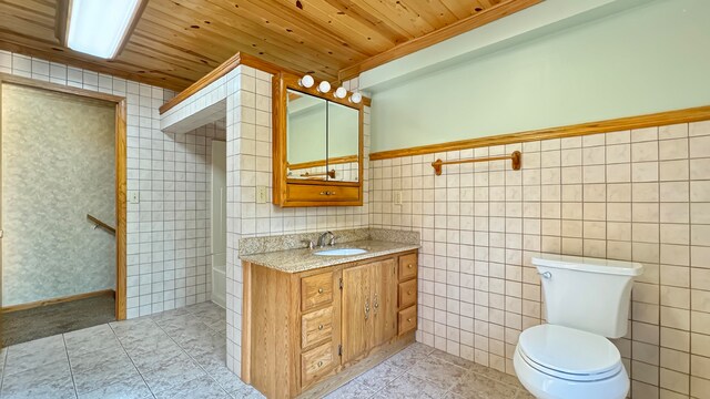 bathroom featuring tile walls, vanity, and toilet