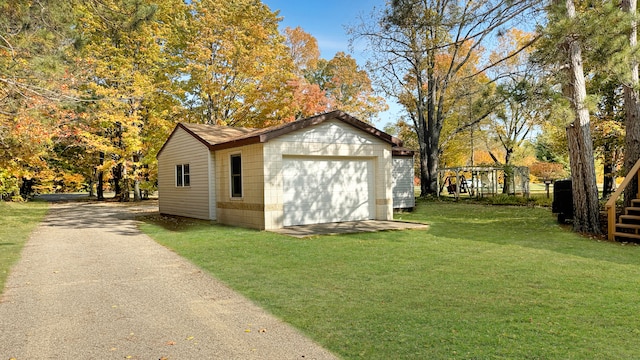 view of outdoor structure with a garage and a lawn