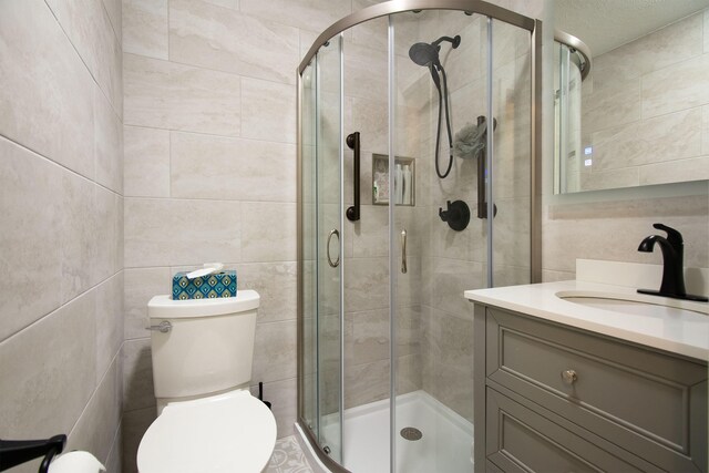 bathroom with vanity, toilet, and a shower with door