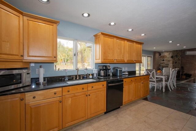 kitchen with black dishwasher, sink, a wall mounted air conditioner, and dark stone counters