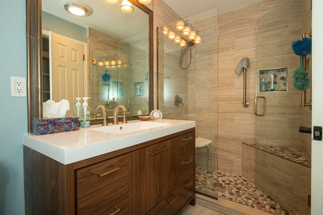 bathroom featuring vanity and a shower with shower door