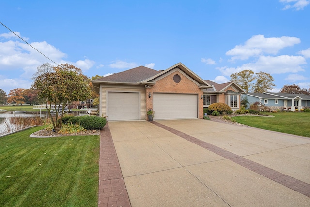 view of front facade featuring a front yard, a garage, and a water view