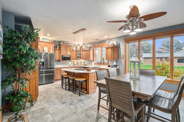 dining space featuring ceiling fan, a textured ceiling, and light tile patterned floors