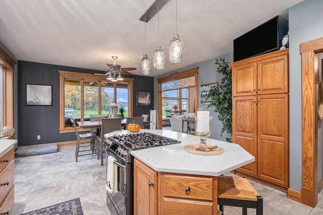 kitchen with ceiling fan, light tile patterned floors, a kitchen island, black range with gas stovetop, and pendant lighting