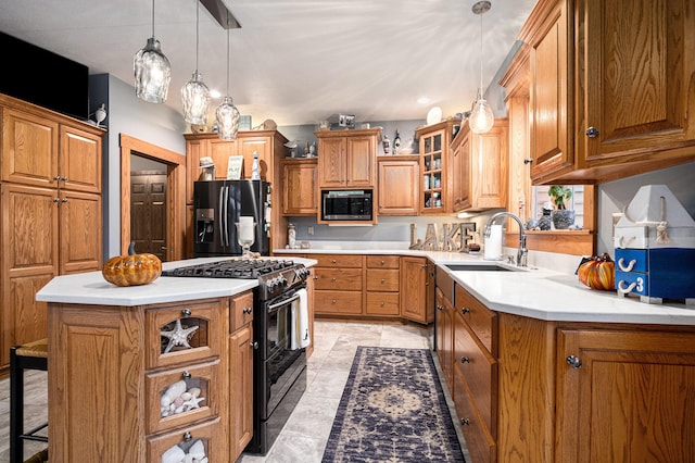 kitchen with a kitchen island, sink, black appliances, a kitchen bar, and pendant lighting