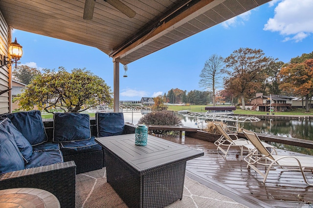 wooden terrace featuring an outdoor living space, a water view, and ceiling fan