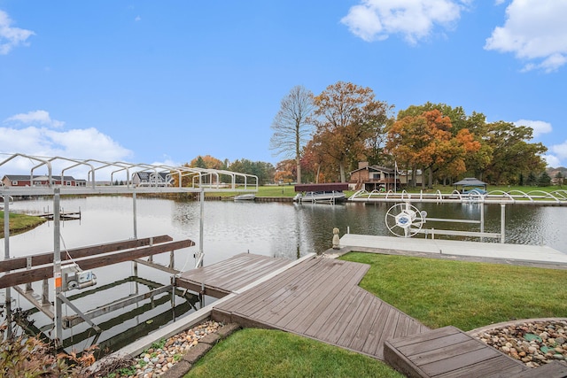 view of dock with a yard and a water view