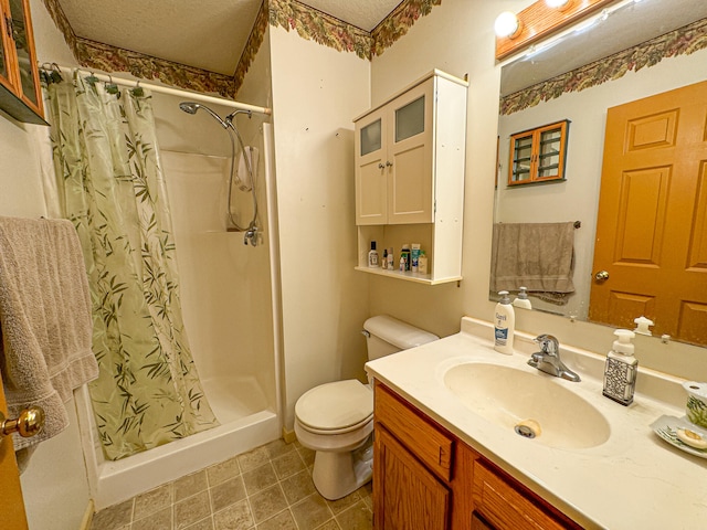 bathroom with vanity, toilet, walk in shower, and a textured ceiling