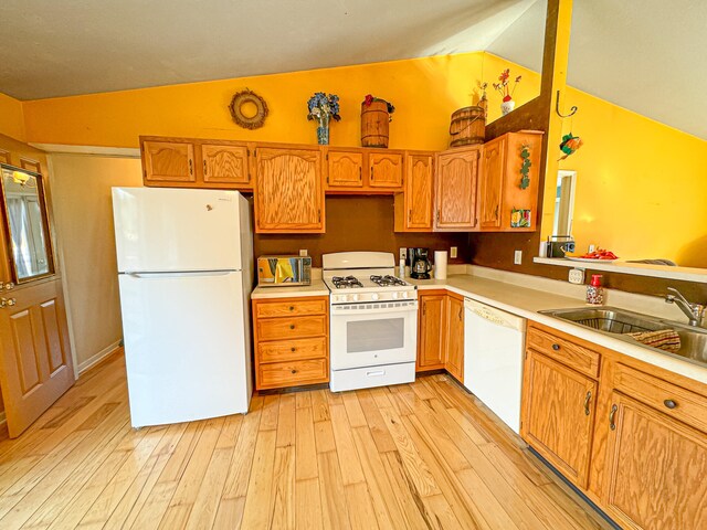 kitchen featuring sink, vaulted ceiling, white appliances, and light hardwood / wood-style floors