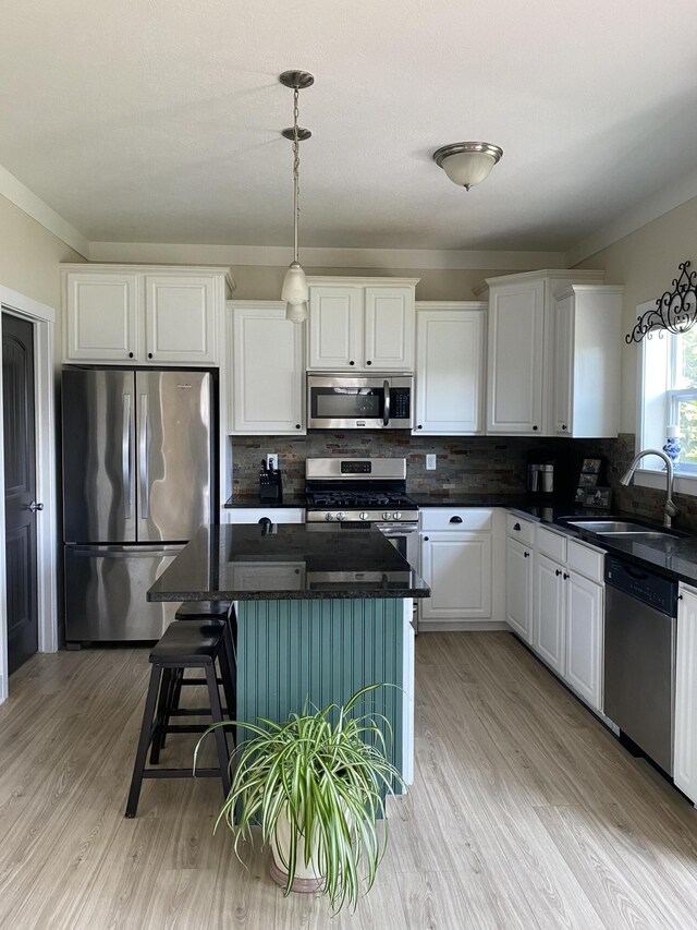 kitchen with white cabinets, stainless steel appliances, backsplash, and a kitchen island