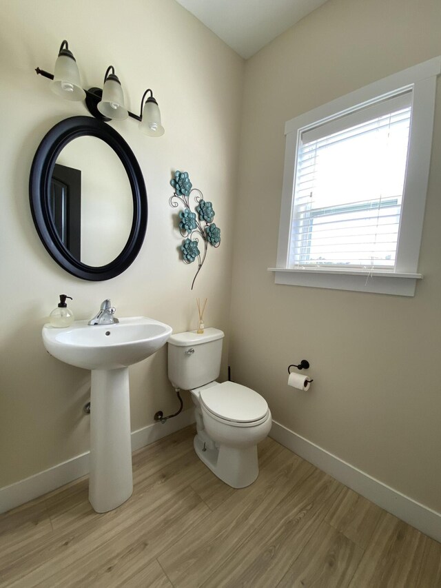 bathroom with toilet and hardwood / wood-style flooring