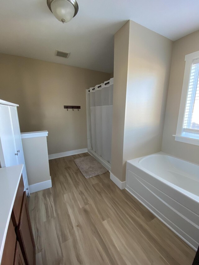 bathroom with vanity, shower with separate bathtub, and hardwood / wood-style flooring