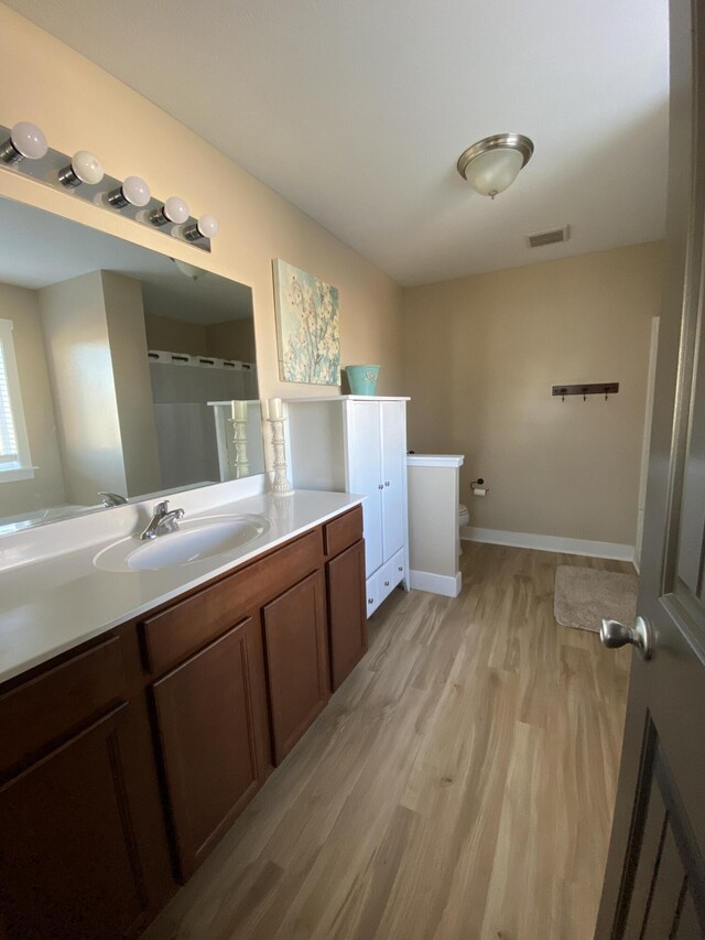 bathroom with vanity, a shower with curtain, hardwood / wood-style flooring, and toilet