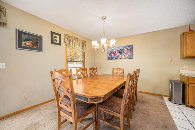 dining room with a textured ceiling, light tile patterned floors, and an inviting chandelier