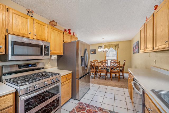 kitchen with pendant lighting, stainless steel appliances, and a textured ceiling