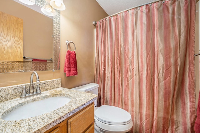 bathroom featuring vanity, curtained shower, a textured ceiling, and toilet