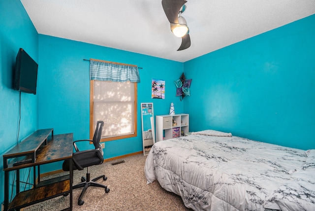 bedroom with ceiling fan, carpet, and a textured ceiling