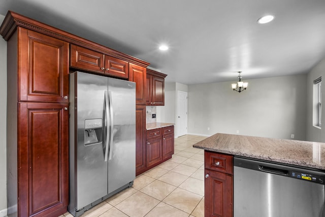 kitchen with light stone counters, light tile patterned flooring, pendant lighting, a notable chandelier, and stainless steel appliances