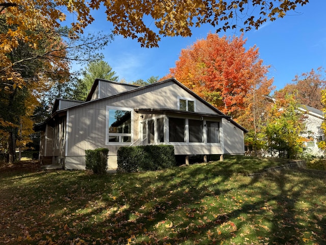 rear view of house with a yard and a sunroom