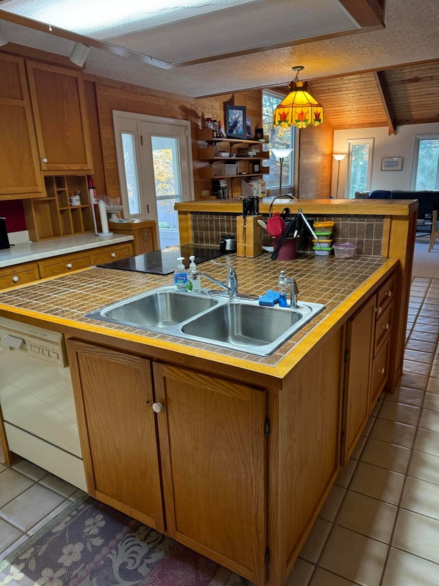 kitchen with a center island with sink, decorative light fixtures, white dishwasher, and light tile patterned floors