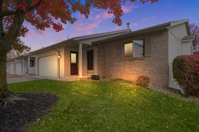 ranch-style house featuring a lawn and a garage