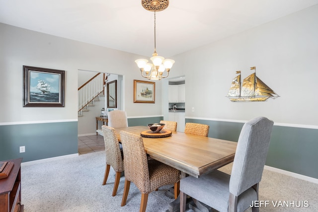 carpeted dining area with an inviting chandelier