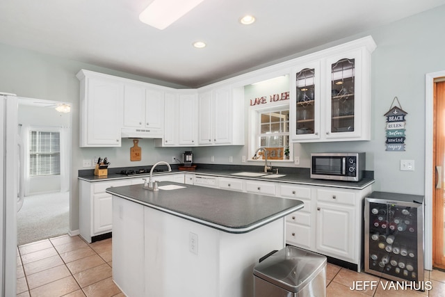 kitchen with white cabinetry, wine cooler, stainless steel appliances, and an island with sink