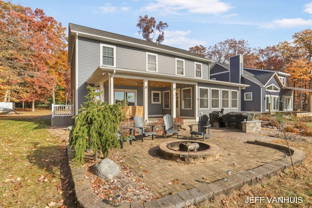 back of house with an outdoor fire pit and a patio area