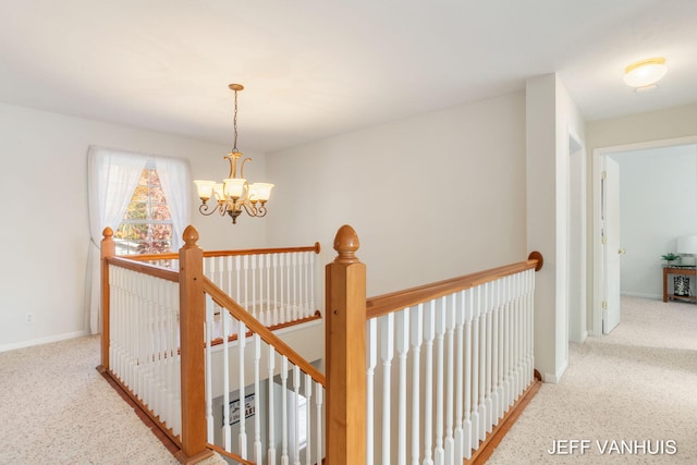 hallway with light carpet and a chandelier