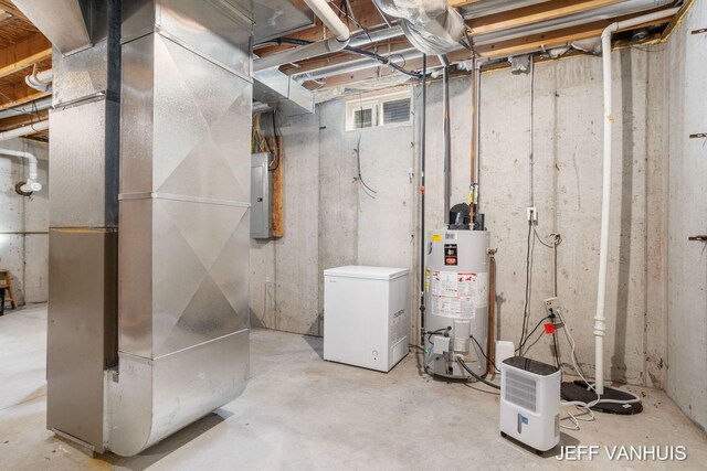 utility room with gas water heater, electric panel, and heating unit