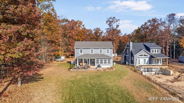 rear view of house with a yard and a sunroom