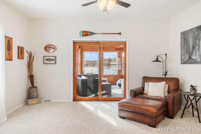 living area with light colored carpet and ceiling fan