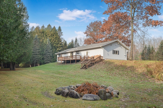 exterior space featuring a wooden deck and a lawn