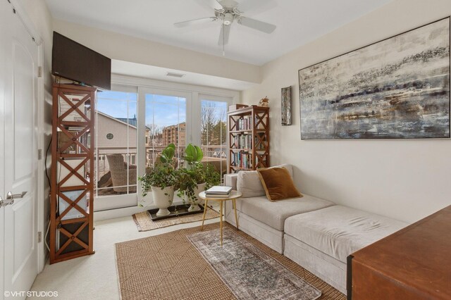 sitting room featuring carpet and ceiling fan