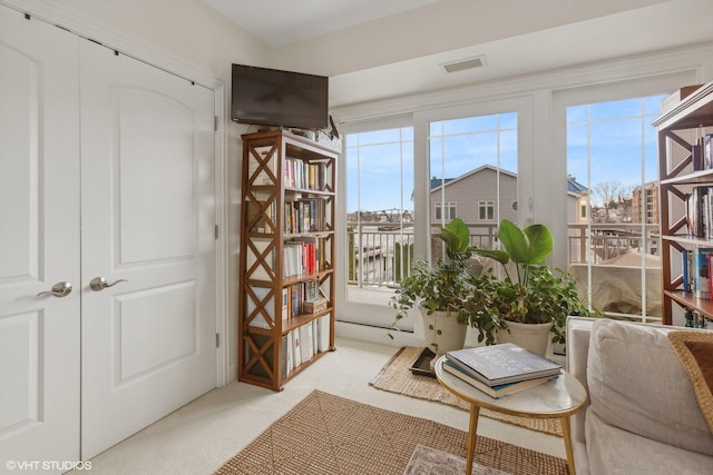 sitting room with a wealth of natural light and light carpet