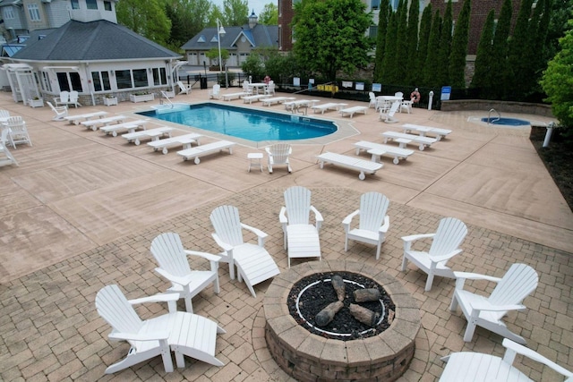 view of pool with an outdoor fire pit and a patio