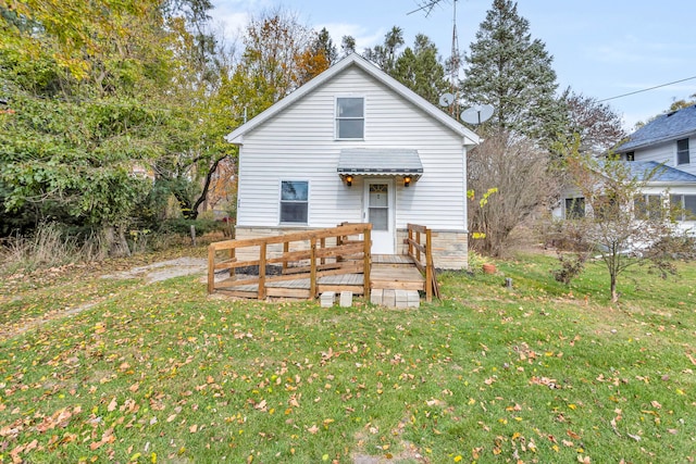 rear view of property with a wooden deck and a yard