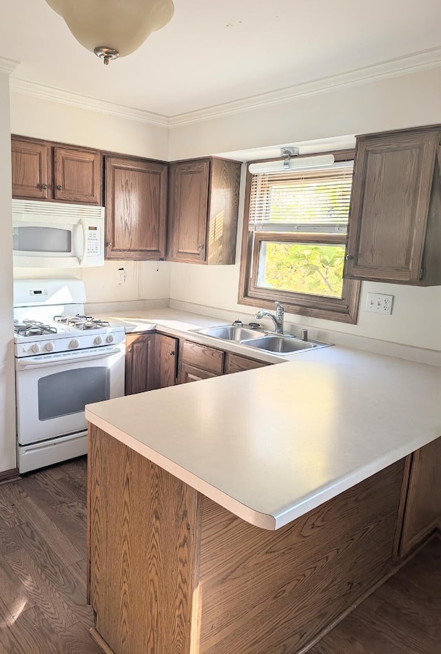 kitchen with kitchen peninsula, dark hardwood / wood-style flooring, ornamental molding, sink, and white appliances