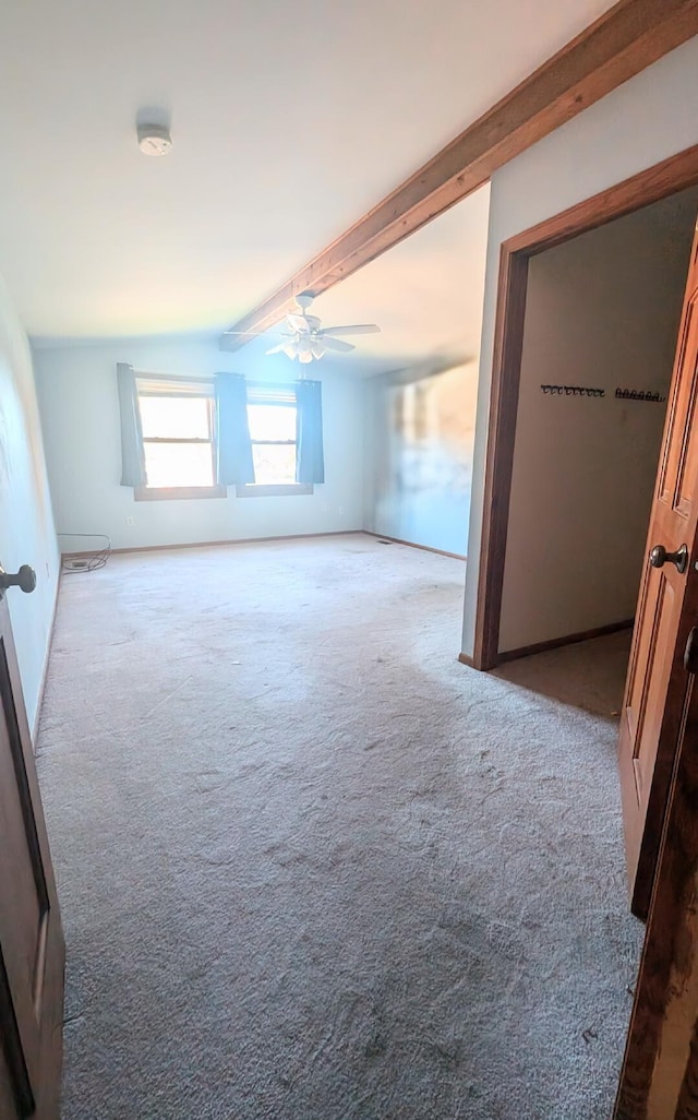 carpeted empty room with lofted ceiling with beams and ceiling fan