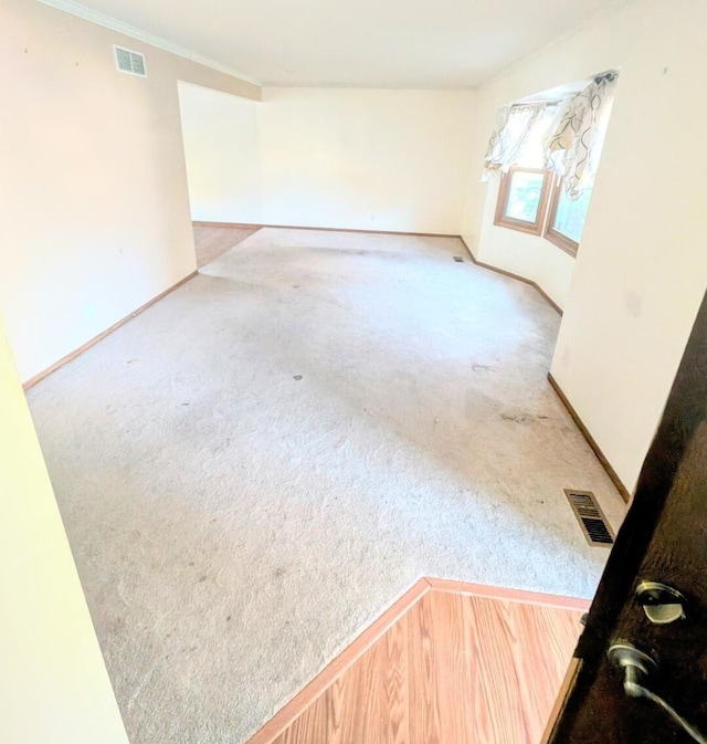 empty room with light carpet and crown molding