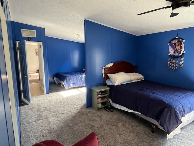 bedroom featuring a textured ceiling, carpet floors, and ceiling fan