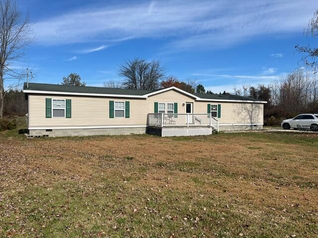 manufactured / mobile home with a deck and a front yard