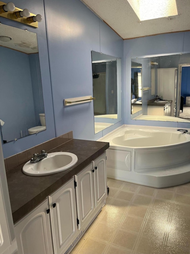 full bathroom with vanity, toilet, a textured ceiling, and plus walk in shower