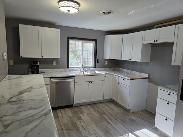 kitchen with dishwasher, light hardwood / wood-style flooring, sink, light stone countertops, and white cabinetry