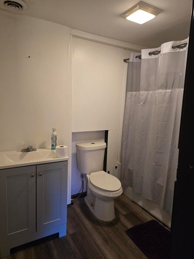 bathroom featuring vanity, hardwood / wood-style floors, toilet, and walk in shower