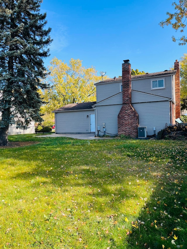 back of property with a patio, a yard, and central air condition unit