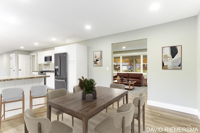 dining space with light hardwood / wood-style flooring