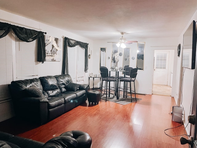 living room with ceiling fan and light hardwood / wood-style flooring