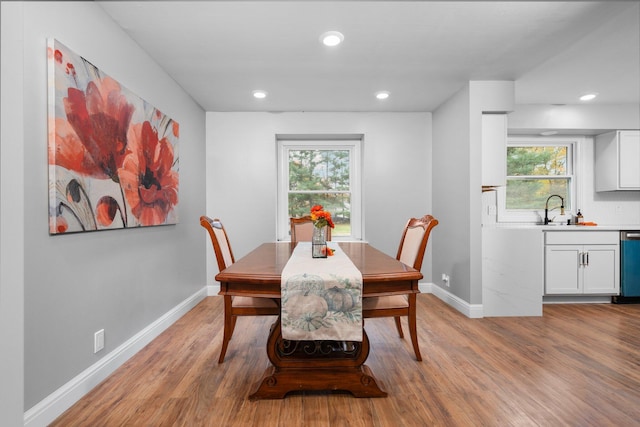 dining room featuring a wealth of natural light, sink, and light hardwood / wood-style flooring